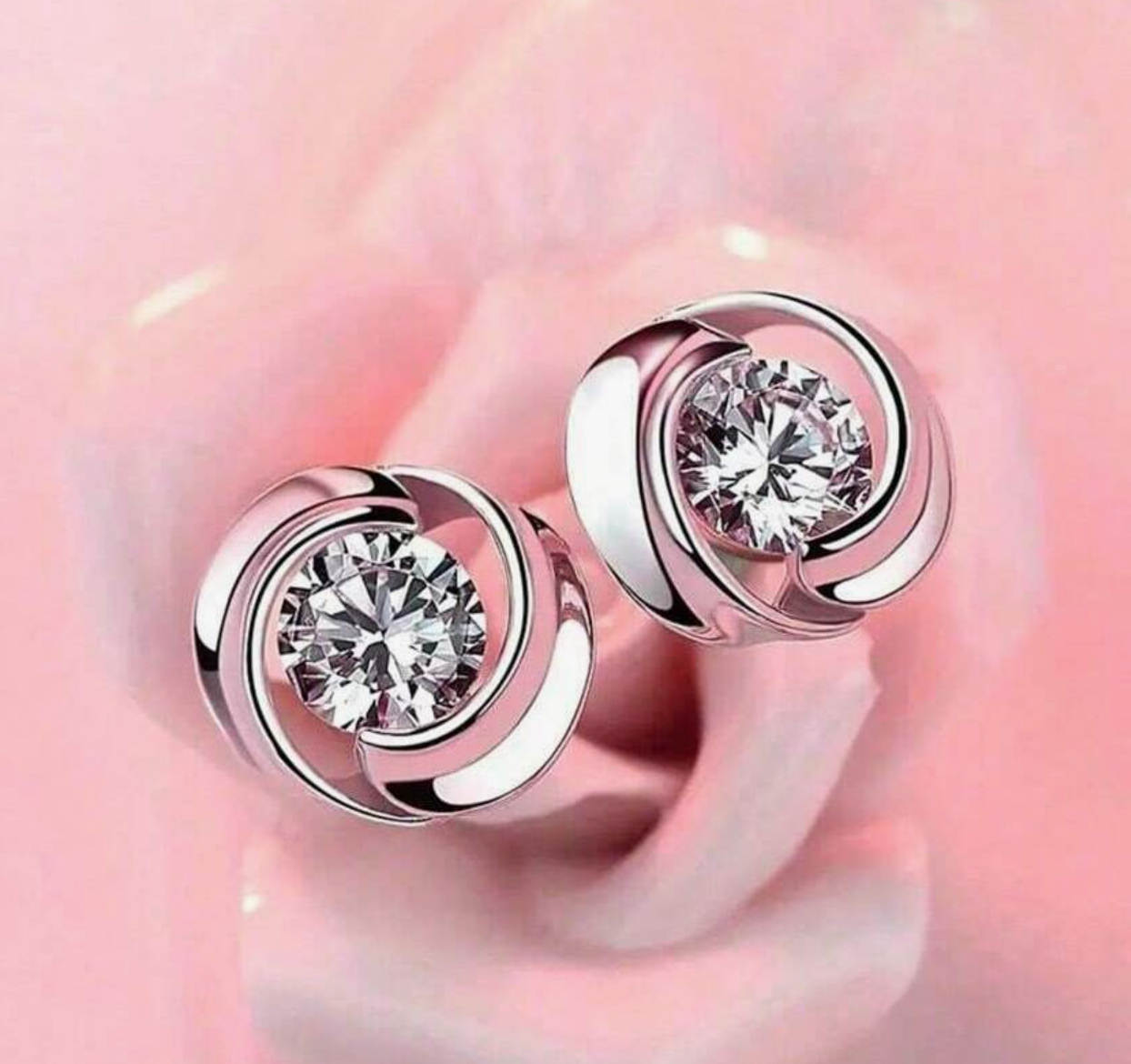 A pair of round earrings set with shiny earrings